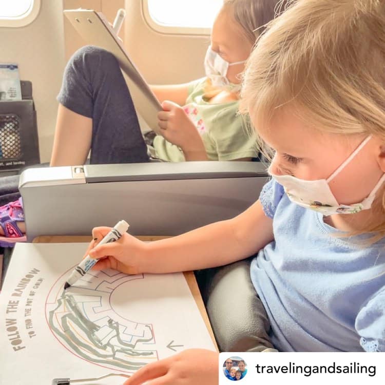 Little girl keeping busy in an airplane during holiday travel | @travelingandsailing