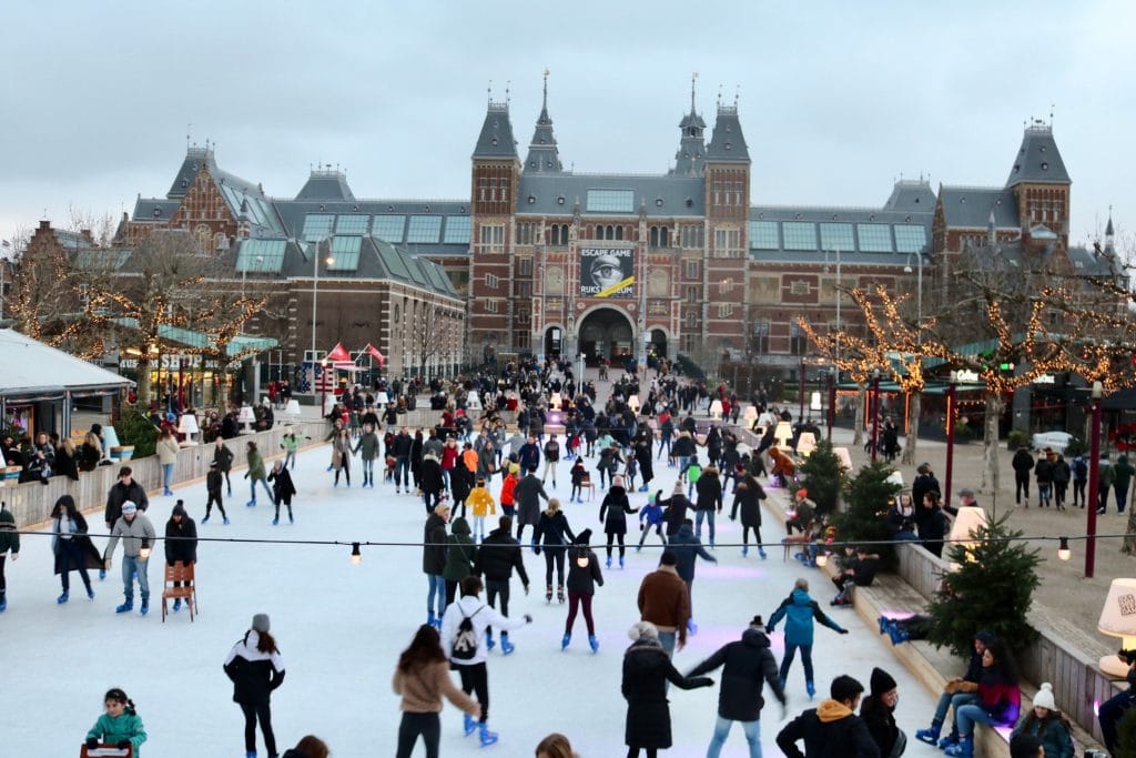 Amsterdam during Christmas. People skating on the ice rink of the main plaza.