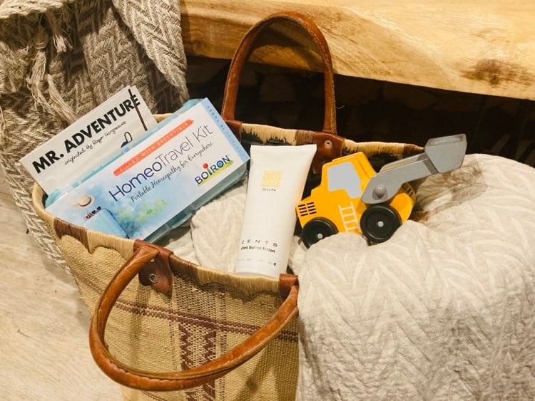 Travel bag filled with homeopathy remedy and other family travel items.