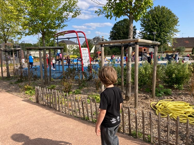 Happy little boy in front a playground.