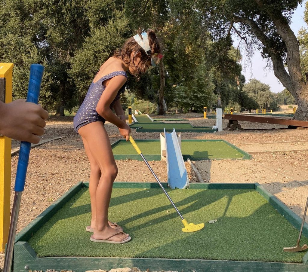 Little girl playing mini-golf in San Benito playground