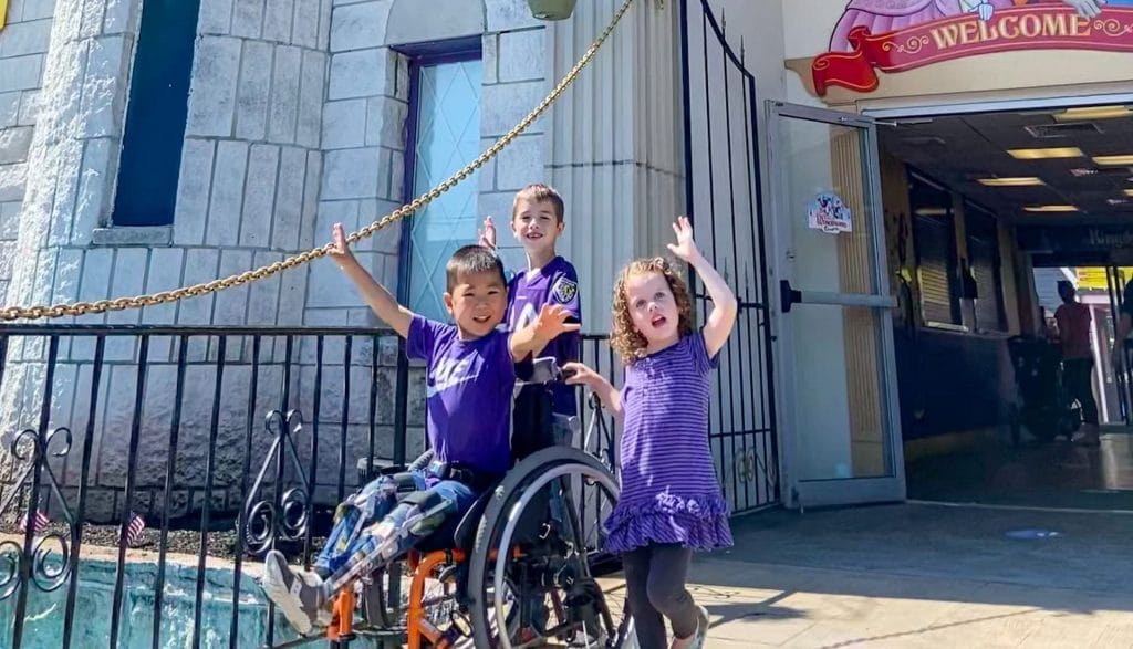 Children, one wheelrchair user in front of an wheelchair vacation sport