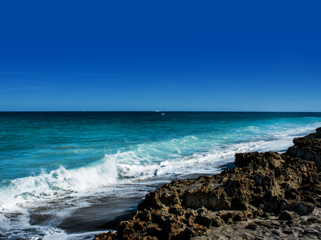 Beach in south florida with waves crashing against rock formation