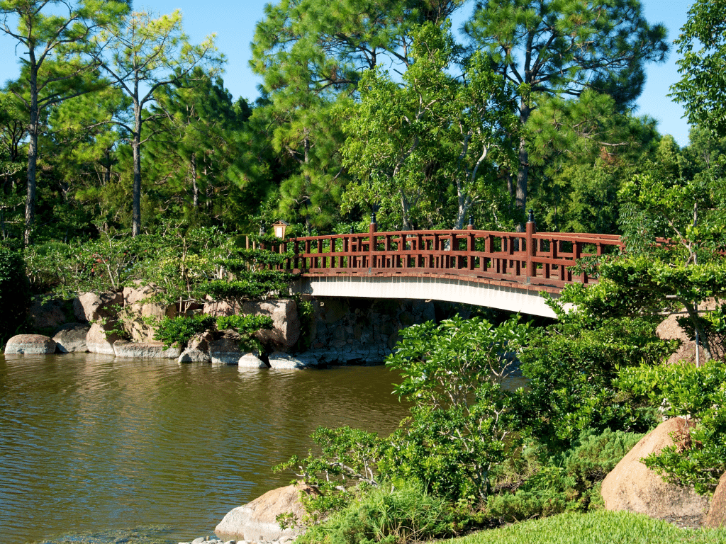 Bridge in the Morikami gardens with lush plants around it.