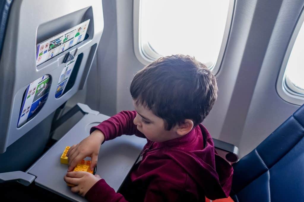 child playing with toy on airplane tray