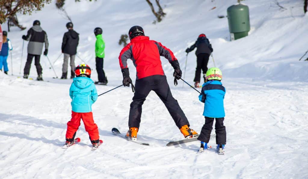 Adult and two children skiing