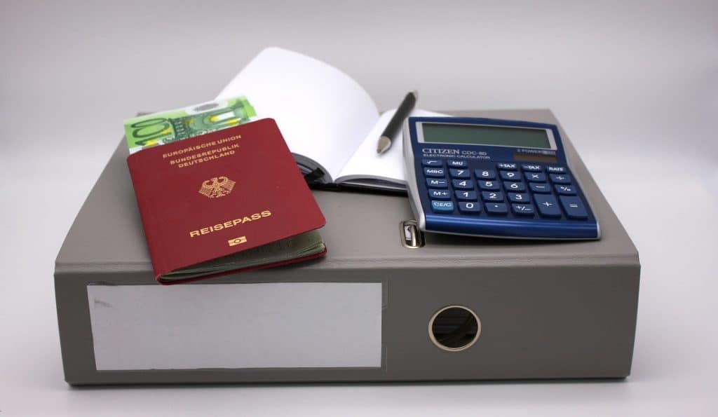 Binder with passeport, calculator and paper work. Family travel insurance.