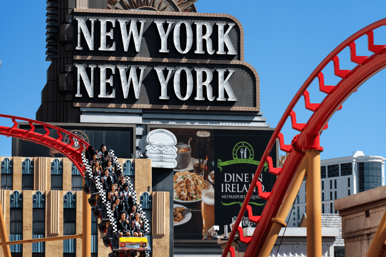 the roller coaster in front of a building with sign New york New york
