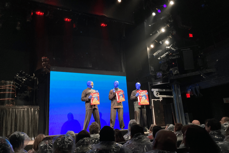 Blue men group presenting an item for their comic part of the show