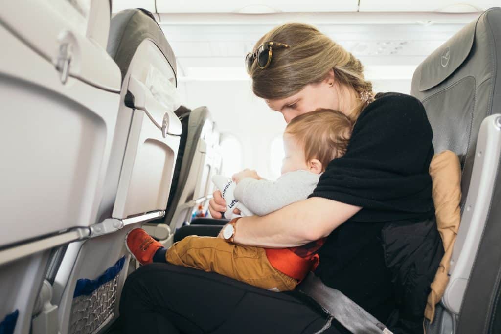 Single parent traveling alone with baby in airplane