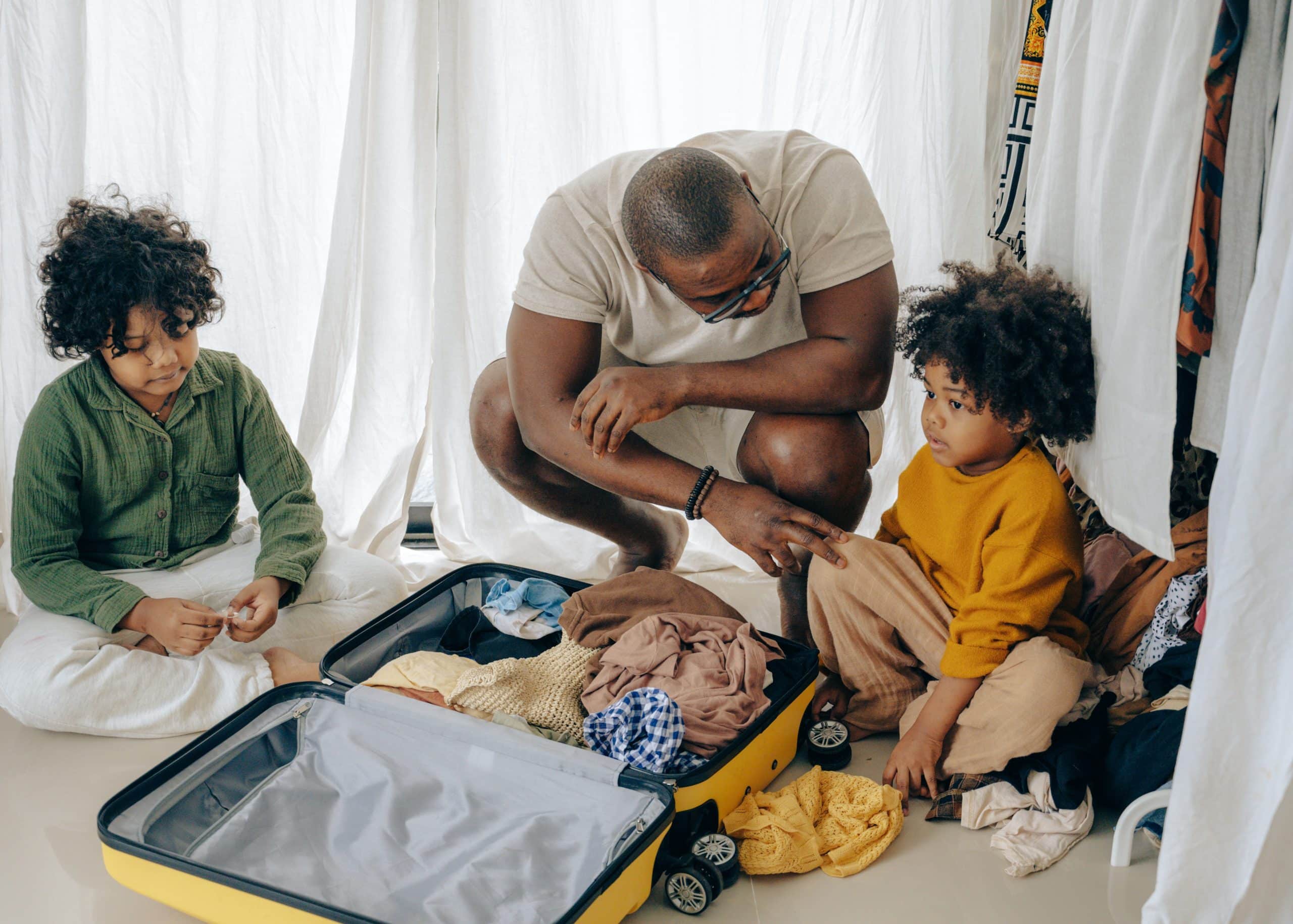 Father and children packing their kids travel suitcase