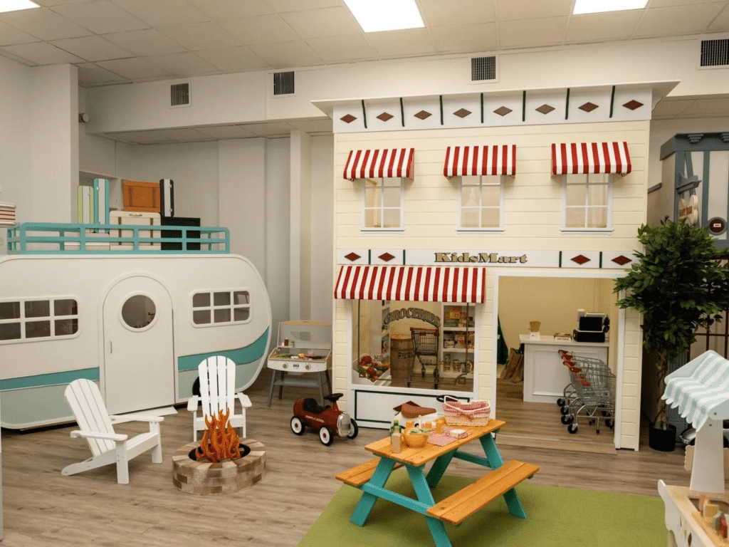 Indoor play space with a mini camper kitchen and chairs
